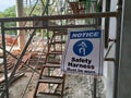 A Ã¢â¬ËSafety Harness Must be WornÃ¢â¬â¢ sign was hung as a reminder to construction workers on site. Royalty Free Stock Photo